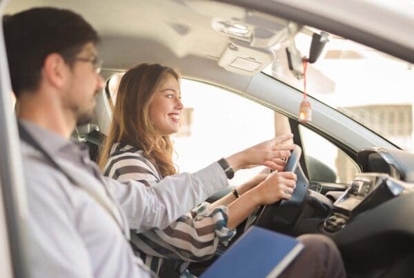 Driving School Insurance - Young Woman Taking a Driving Test With Her Instructor on a Sunny Day